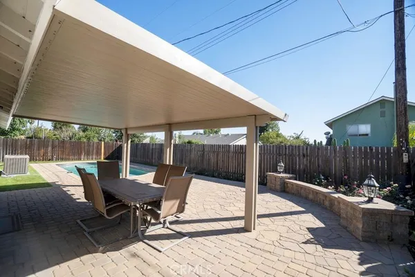 a view of a patio with a table and chairs under an umbrella