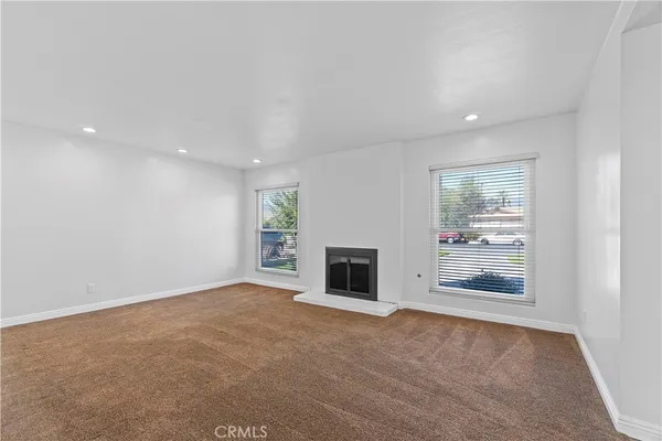 an empty room with fireplace and windows