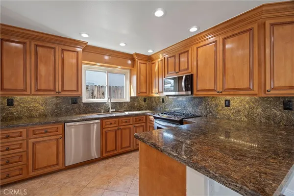 a kitchen with stainless steel appliances granite countertop a sink stove and microwave