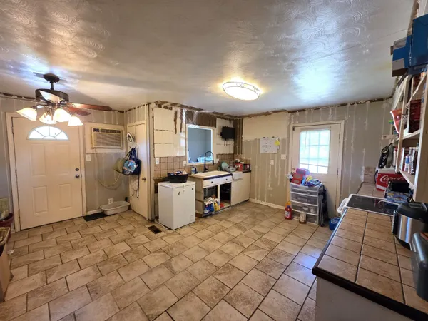 a kitchen that has a lot of cabinets and refrigerator in it