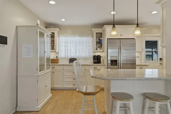 a kitchen with stainless steel appliances granite countertop a refrigerator a stove and a sink