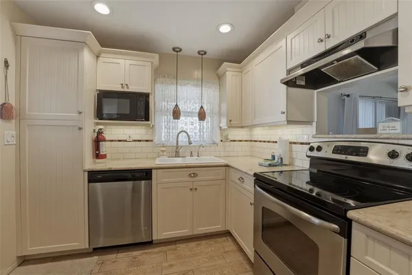 a kitchen with a sink stove and microwave