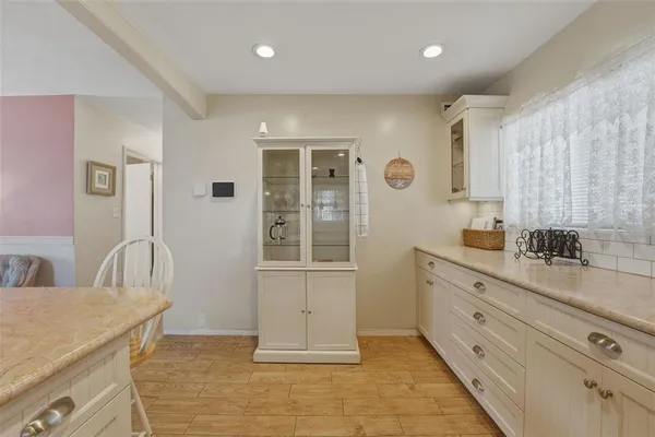 a spacious bathroom with a granite countertop sink a mirror and a bathtub