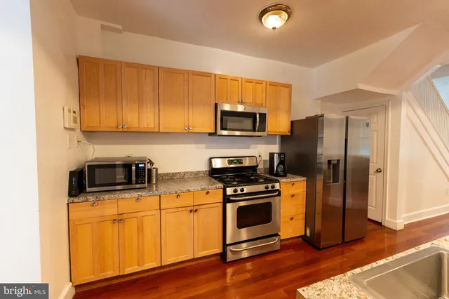 a kitchen with wooden cabinets and stainless steel appliances