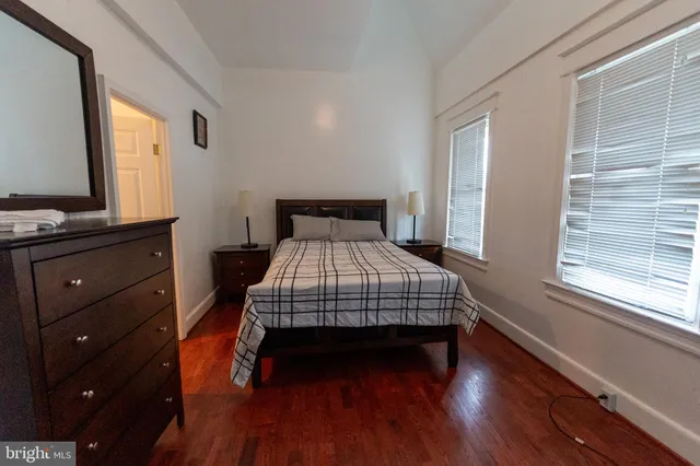 a bedroom with a bed and a flat tv screen on dresser