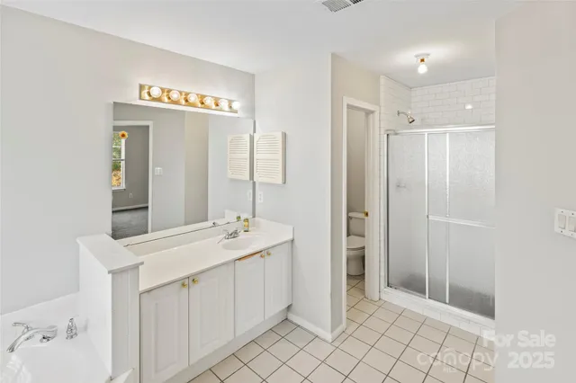 a spacious bathroom with a shower sink and mirror
