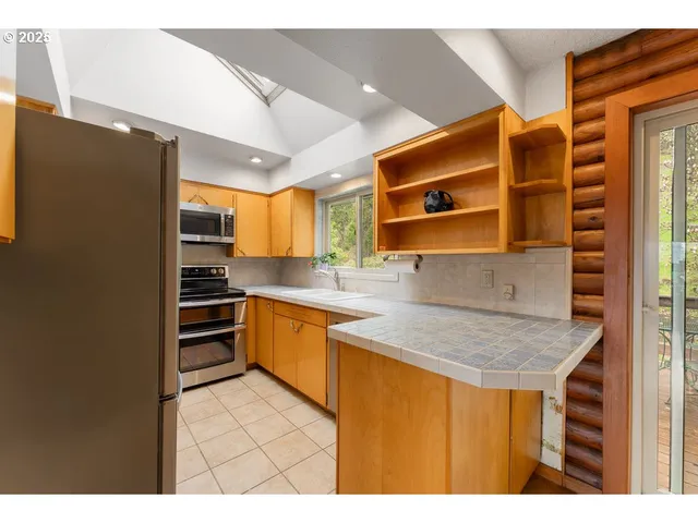 a kitchen with stainless steel appliances a stove a refrigerator and a sink