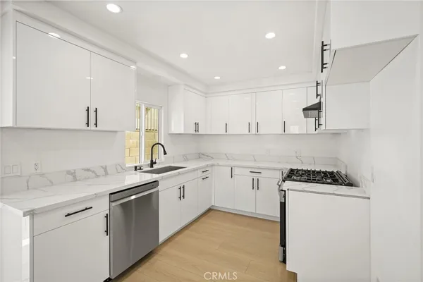 a kitchen with a sink a stove and cabinets