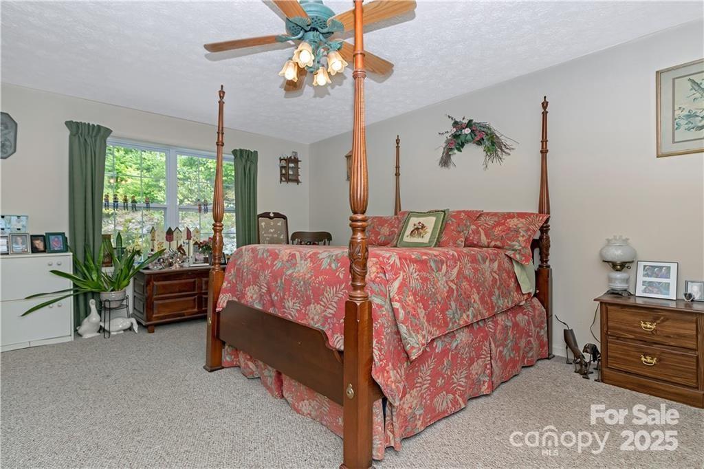 612 Old Home Place Road Tuckasegee, NC 28783 - Photo 21 of 42 a bed room with a bed and a chandelier