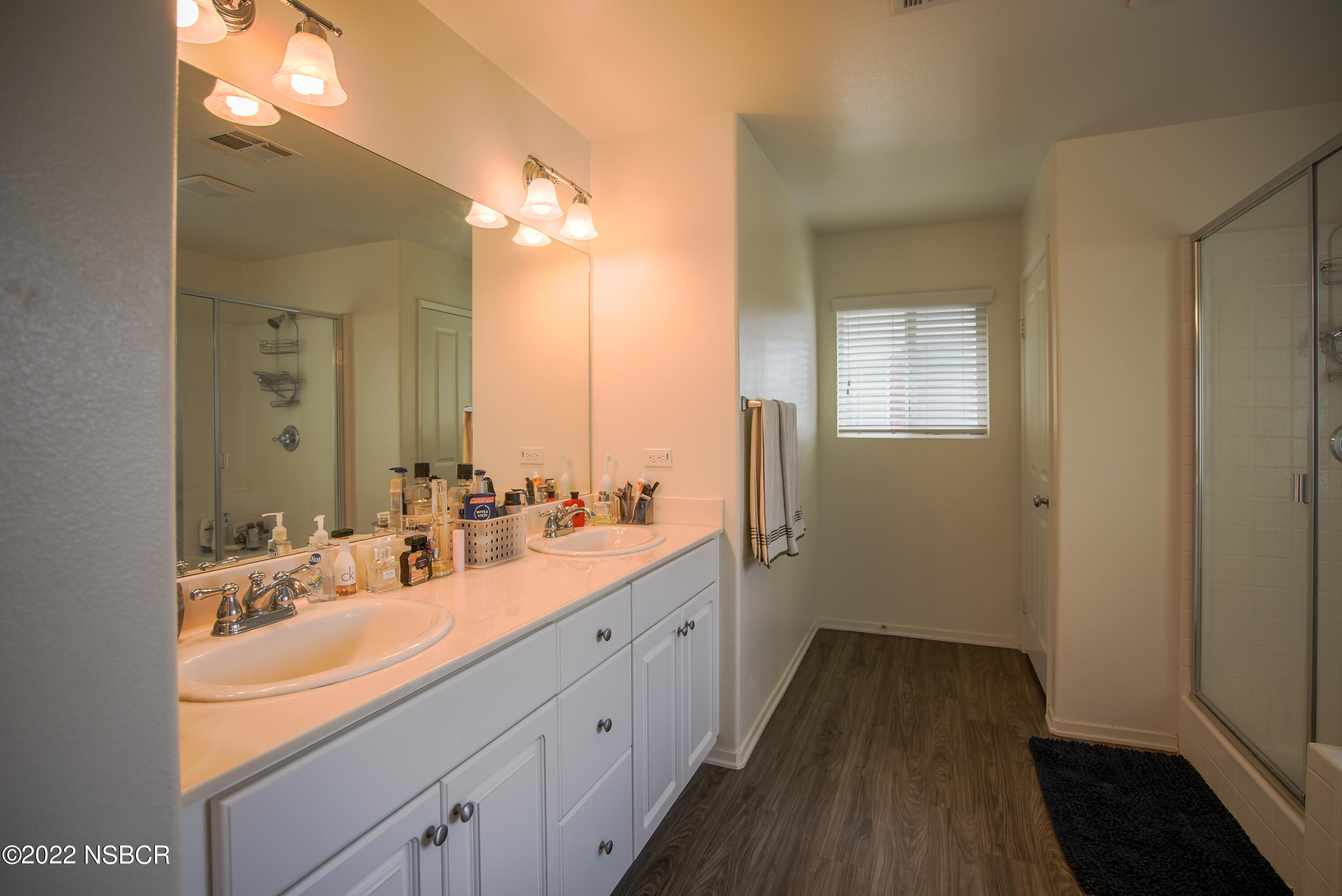 1307 Crown Circle Lompoc, CA 93436 - Photo 18 of 34 a bathroom with a double vanity sink and mirror with shower