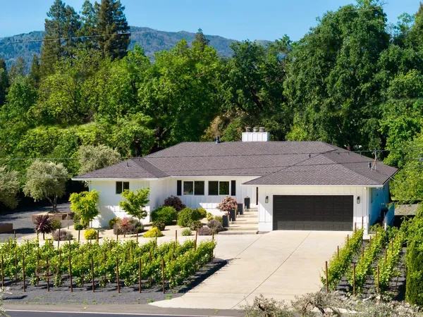 a front view of a house with a yard garage and outdoor seating