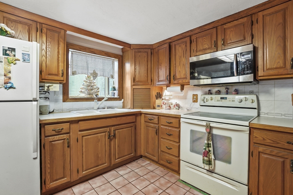 38 Candice Street Clinton, MA 01510 - Photo 2 of 13 a kitchen with stainless steel appliances granite countertop a stove a sink and a microwave