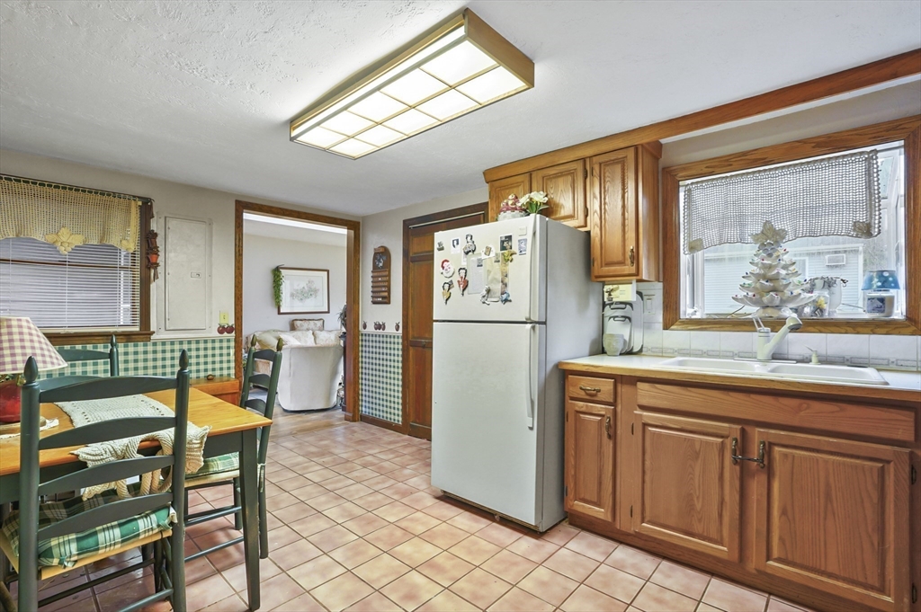 38 Candice Street Clinton, MA 01510 - Photo 4 of 13 a kitchen with stainless steel appliances granite countertop a refrigerator a stove a sink and a dining table with wooden cabinet