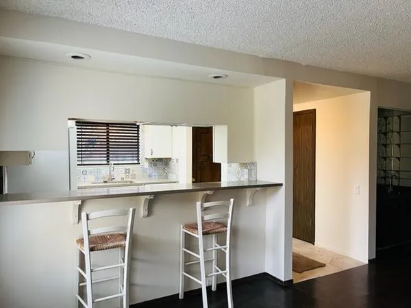 a kitchen with granite countertop cabinets and chair