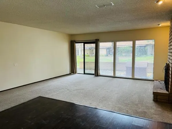 a view of an empty room with a fireplace and a floor to ceiling window