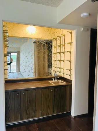 a bathroom with a granite countertop sink and a large mirror