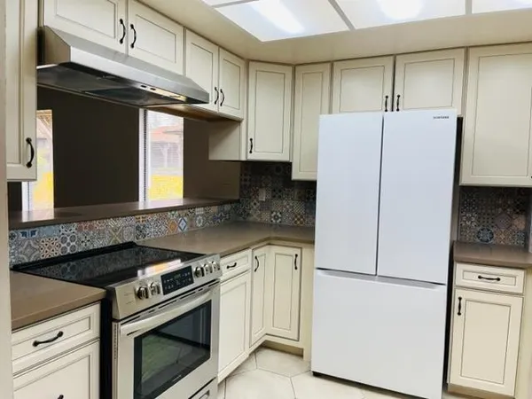 a kitchen with a stove a refrigerator and a sink
