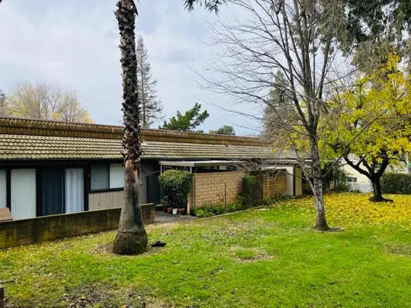 a view of a house with backyard and sitting area
