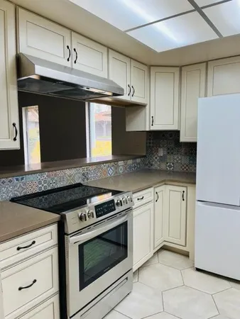 a kitchen with granite countertop a stove and a sink