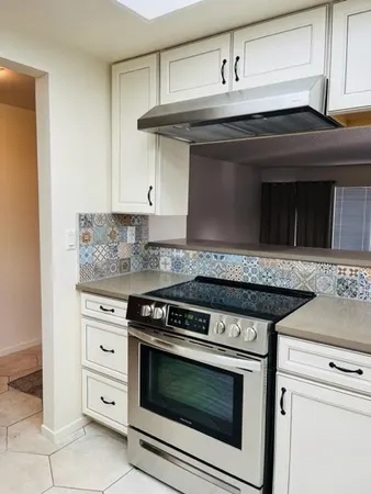 a stove top oven sitting inside of a kitchen