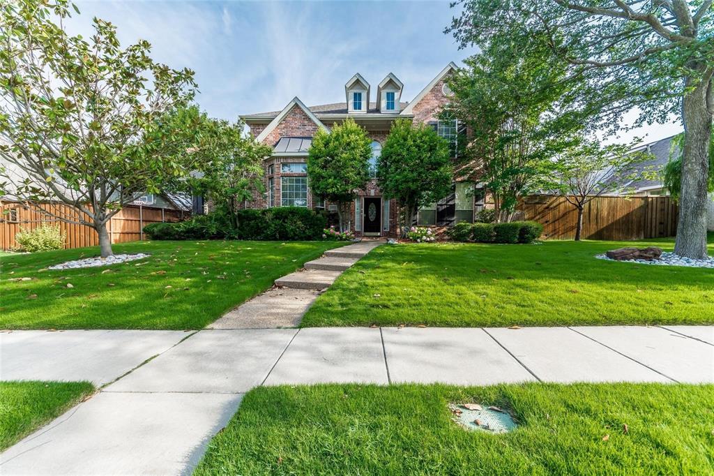 a front view of a house with a yard and potted plants