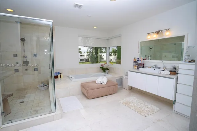 a bathroom with a tub sink mirror and shower