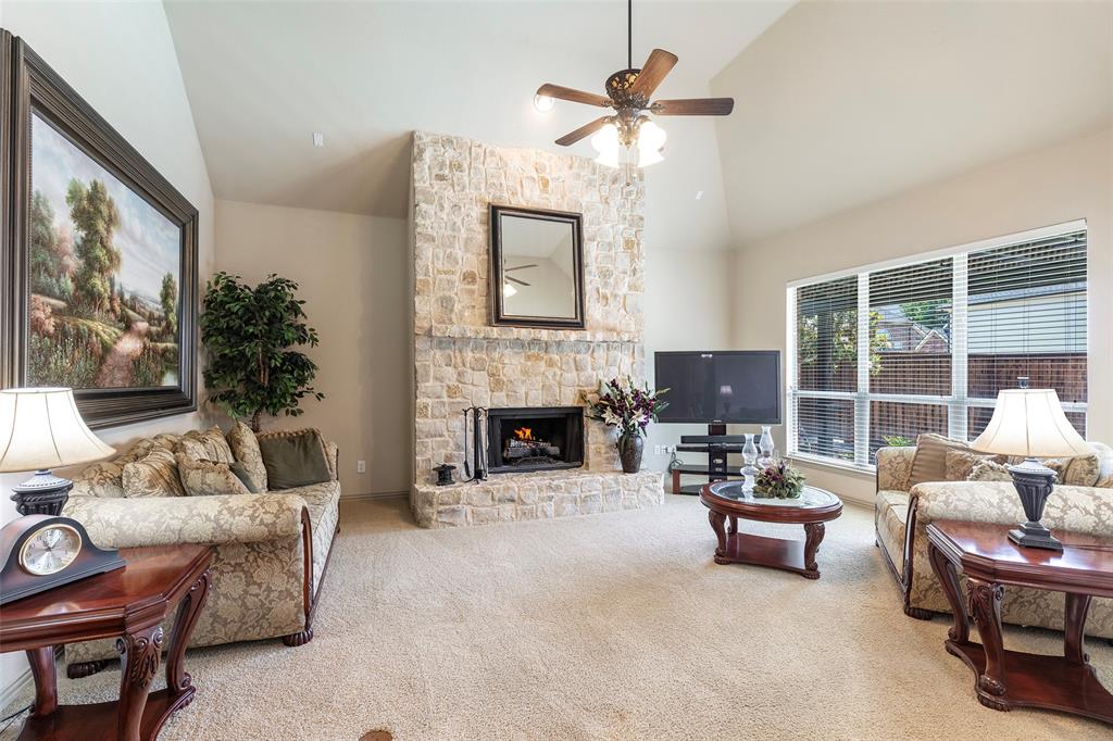 1217 Windmere Way Allen, TX 75013 - Photo 14 of 38 Anchored by a dramatic floor-to-ceiling stone fireplace, the spacious living room offers a warm and welcoming setting for relaxing evenings at home.