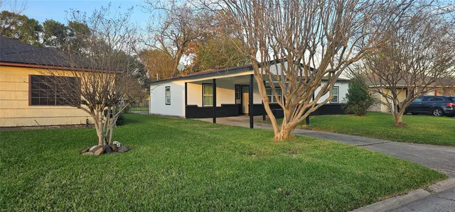 a view of a house with backyard and a tree