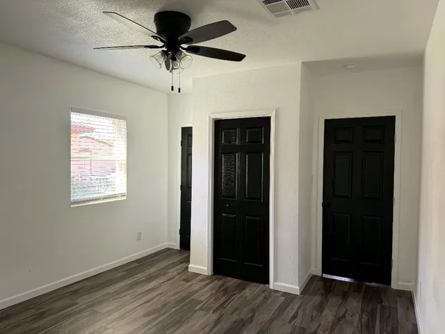 a view of a livingroom with a chandelier fan and a window