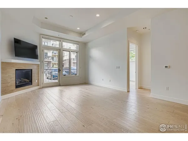 a view of an empty room with a fireplace and a window