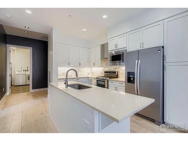 a view of open kitchen with white cabinets and a fireplace