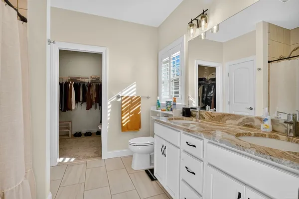 a bathroom with a granite countertop sink mirror and toilet