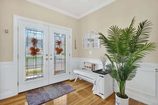 a living room with furniture a potted plant and a large window