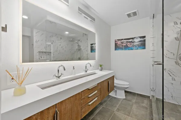 a bathroom with a sink a toilet and mirror