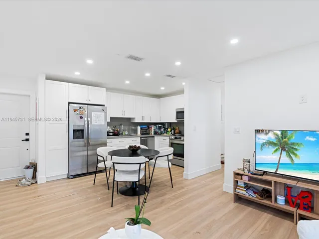 a kitchen with stainless steel appliances kitchen island granite countertop a refrigerator and a stove top oven