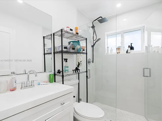 a bathroom with a sink a toilet and shower