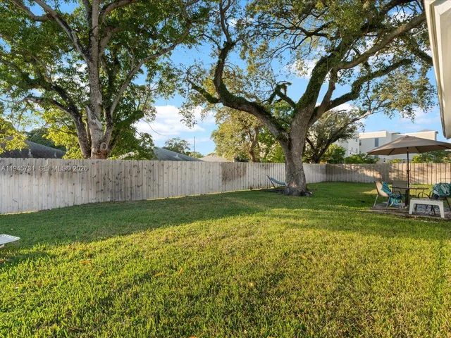a view of backyard with table and chairs and wooden fence