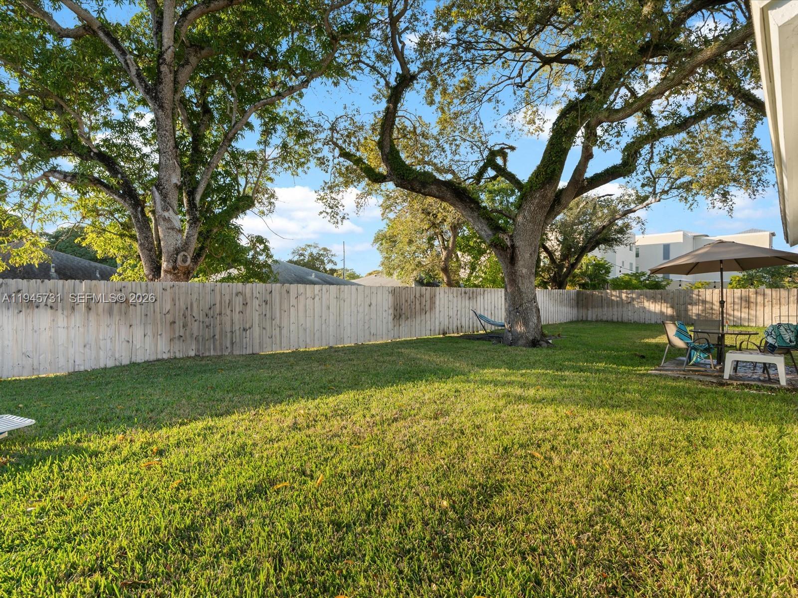 6510 Southwest 59th Place South Miami, FL 33143 - Photo 4 of 23 a view of backyard with table and chairs and wooden fence