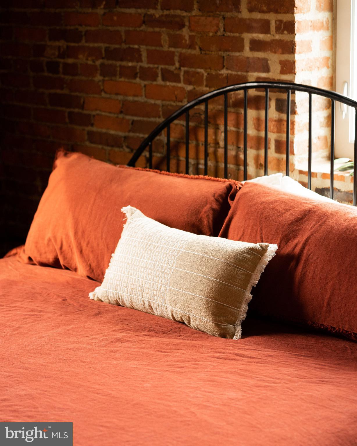 437 West Grant Street, Unit 304 Lancaster, PA 17603 - Photo 14 of 37 a bed sitting in a bedroom next to a window