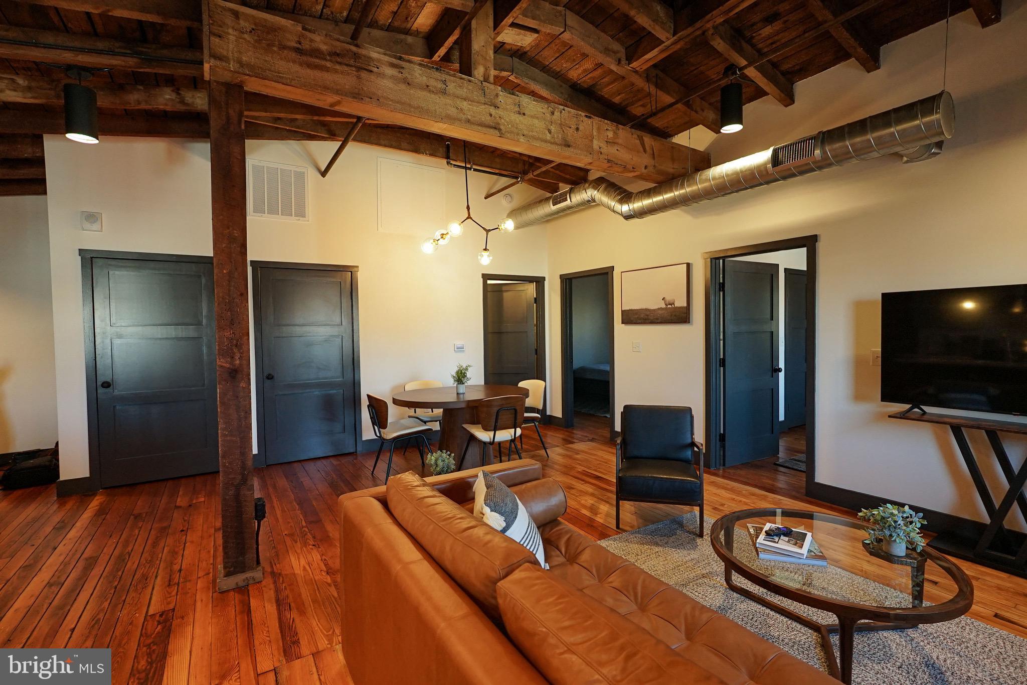 437 West Grant Street, Unit 304 Lancaster, PA 17603 - Photo 2 of 37 a living room with furniture a flat screen tv and wooden floor