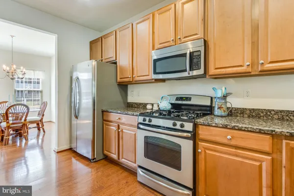 a kitchen with stainless steel appliances granite countertop a stove microwave refrigerator and cabinets