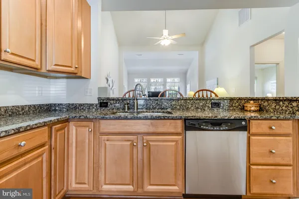 a kitchen with granite countertop white cabinets and stainless steel appliances