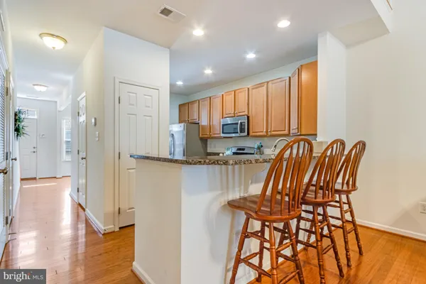 a view of kitchen with stainless steel appliances granite countertop furniture and a refrigerator