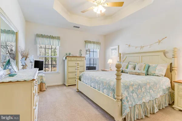 a spacious bedroom with a bed and a chandelier
