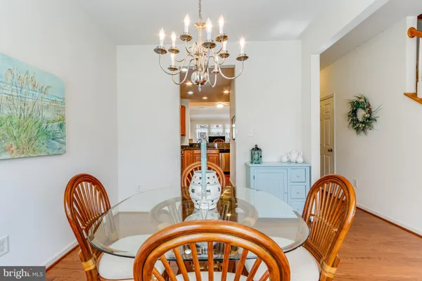 a dining room with furniture a chandelier and wooden floor