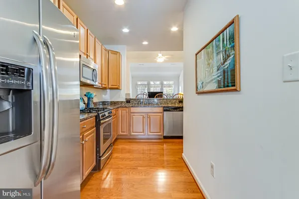 a kitchen with stainless steel appliances granite countertop a refrigerator a stove and a sink