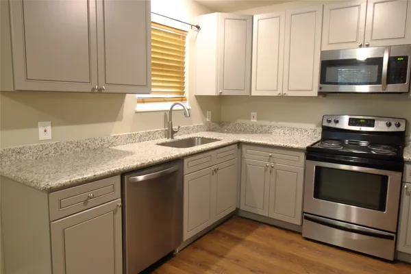 a kitchen with granite countertop cabinets stainless steel appliances and a sink