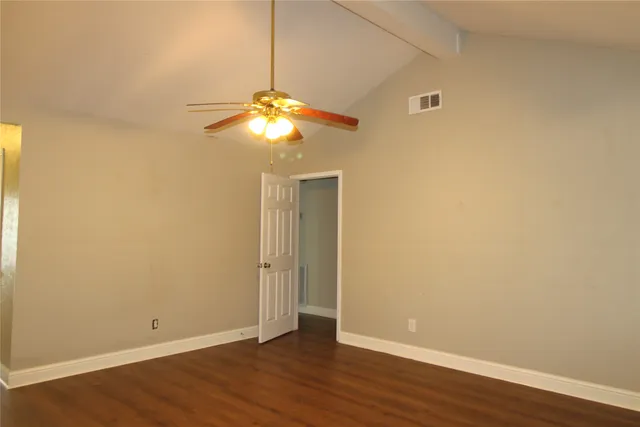 an empty room with wooden floor and chandelier fan