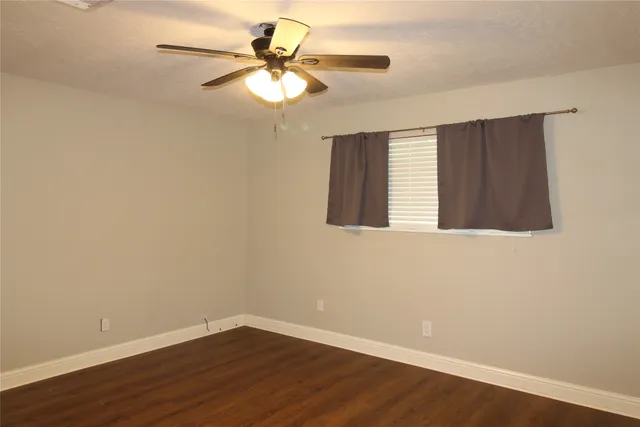 a view of a small space with wooden floor and a chandelier fan