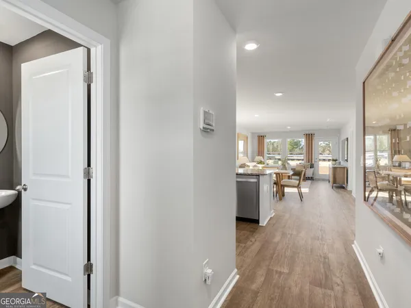a kitchen with stainless steel appliances kitchen island granite countertop a stove top oven a sink dishwasher a dining table and chairs with wooden floor